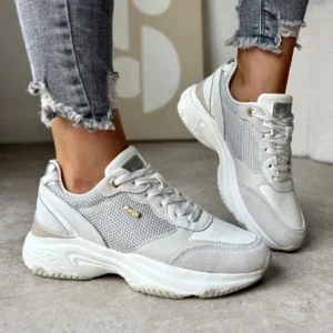 LULA 84 – sportowe adidasy damskie z białej skóry naturalnej z siateczką i beżowymi akcentami, prezentowane na modelce w szarych jeansach