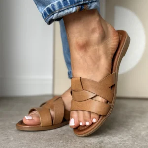 Brązowe skórzane klapki damskie LULA 88 na stopie – widok z boku na tle jasnej podłogi i jeansów.