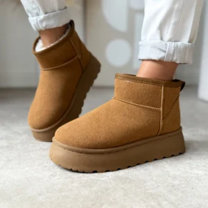 Śniegowce damskie LULA 139 w kolorze camel, ocieplane futerkiem, na grubej platformie, widok z boku na nodze modelki w jasnych spodniach.