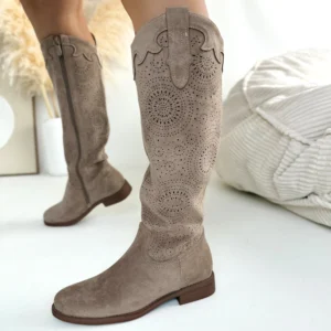 Beżowe zamszowe kozaki damskie z ażurową cholewką LULA 163 na płaskiej podeszwie, prezentowane na nodze kobiety.