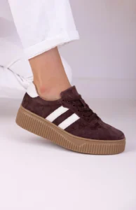 Brązowe trampki z białymi paskami na grubej podeszwie – model Lula 38 na nodze w jeansach