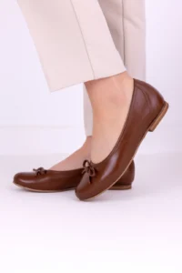 Brązowe skórzane baleriny damskie LULA 177 z kokardką, wykonane z miękkiej włoskiej skóry naturalnej, prezentowane na stopach i w dłoniach, minimalistyczne tło.