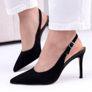 Czarne czółenka damskie na szpilce wykonane z naturalnego zamszu, z paskiem przy pięcie, noszone do białych spodni w eleganckiej stylizacji.